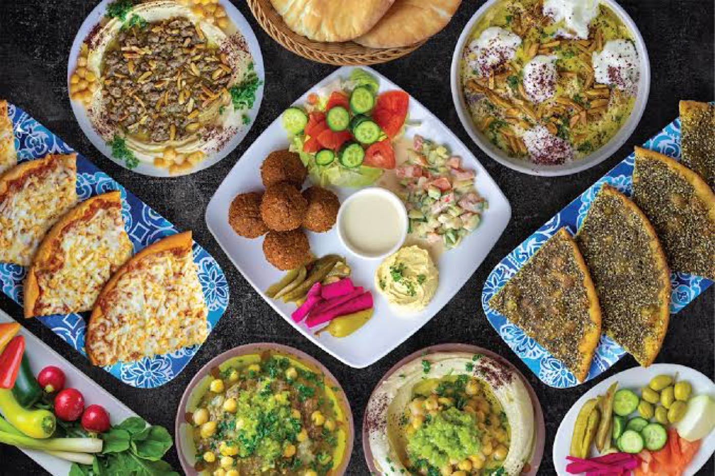 A spread of manakish, kibbeh, foul, tabouleh and fresh pita from the Falafel Plus kitchen.